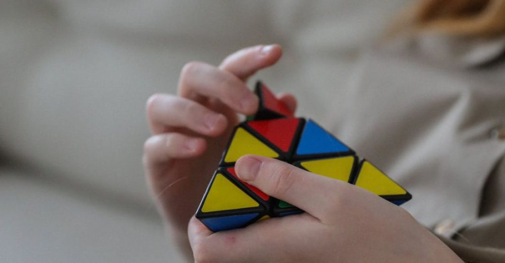 Crop Rotation - Unrecognizable girl twisting combination puzzle at home