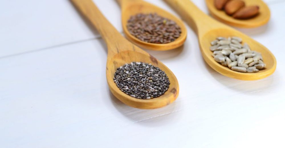 Seeds - Closeup Photo of Four Brown Wooden Spatulas With Seds